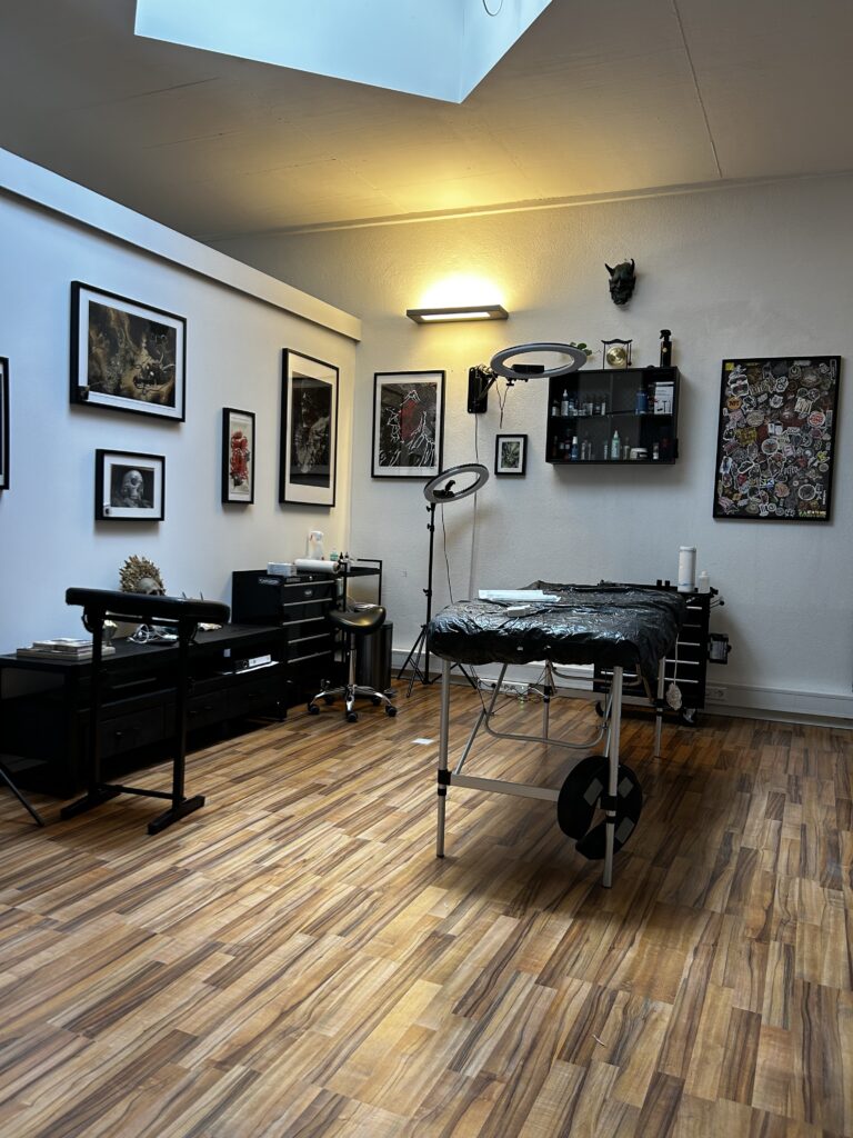 Tattoo-Raum im Golden Circle Tattoo Studio in Karlsruhe mit Kunstwerken an den Wänden