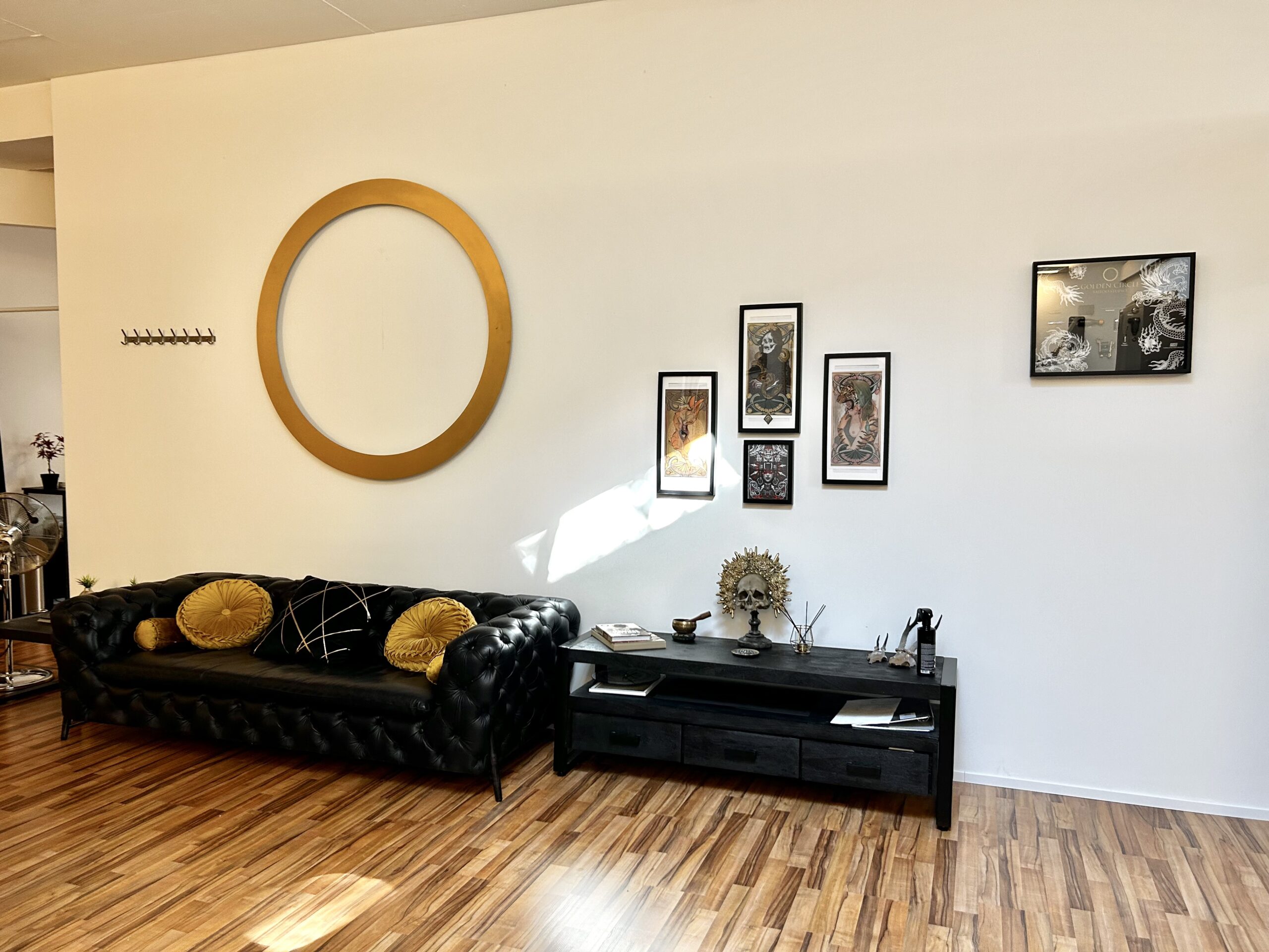 Loungebereich im Golden Circle Tattoo Studio mit dekorativen Kunstwerken