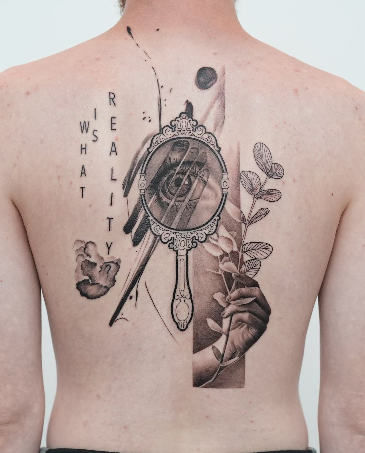 Symbolisches Rücken-Tattoo mit Auge und botanischen Elementen in Karlsruhe.